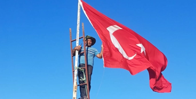 Muhtarı olduğu köyün en yüksek tepesine Türk bayrağı dikti
